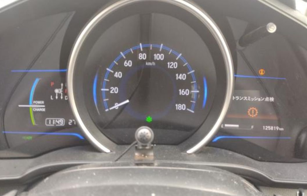 Instrument cluster showing 125,819 km and a transmission check message
