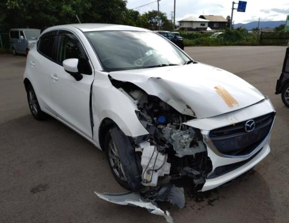 Front right of the Mazda Demio with the bumper torn away
