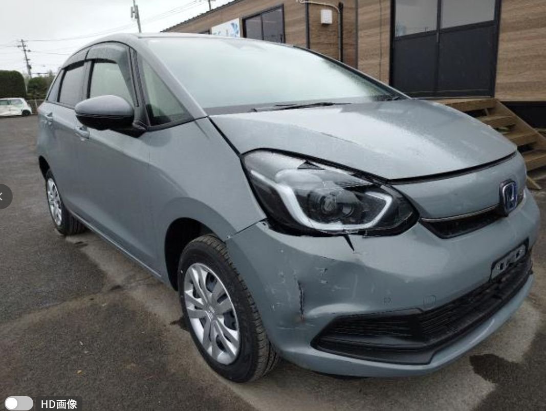 Grey Honda Fit seen from the front right with front-right corner damage