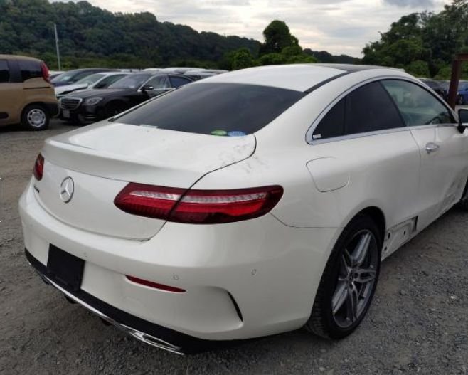 Pearl white Mercedes-Benz E200 Coupe seen from the rear right