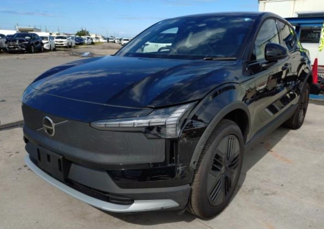 Black Volvo EX30 Cross Country seen from the front left, showing the damaged headlight and bumper corner