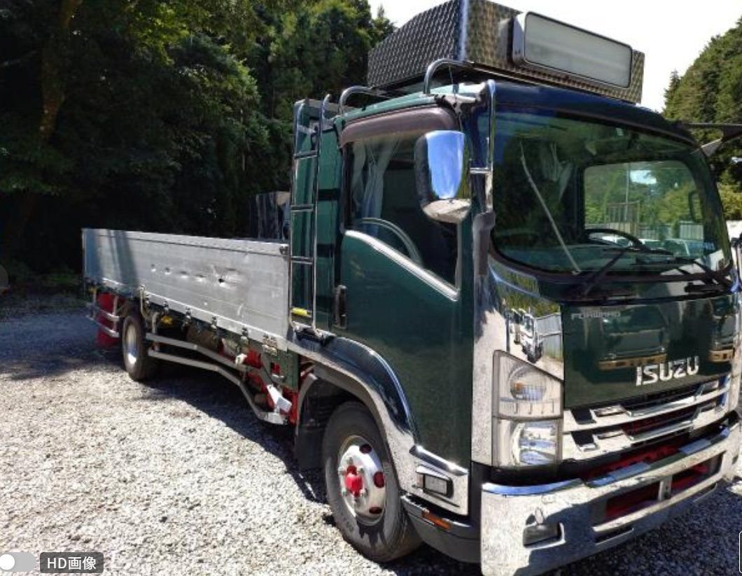 Green Isuzu Forward flat-deck truck seen from the front right
